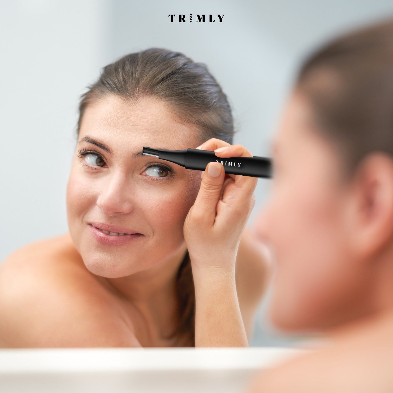 Vrouw gebruikt Trimly wenkbrauwtrimmer voor precieze styling.