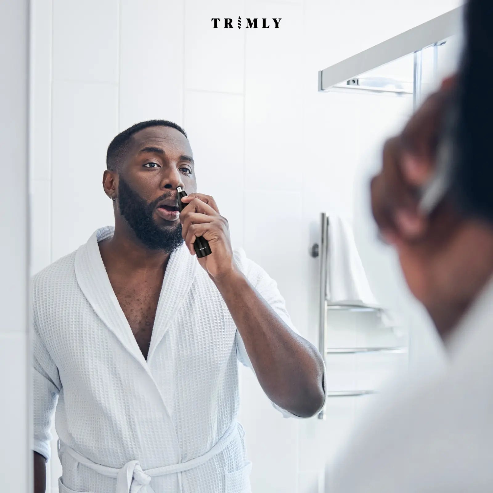 Man gebruikt de Trimly neustrimmer voor een snelle en pijnloze neushaarverzorging in de badkamer.